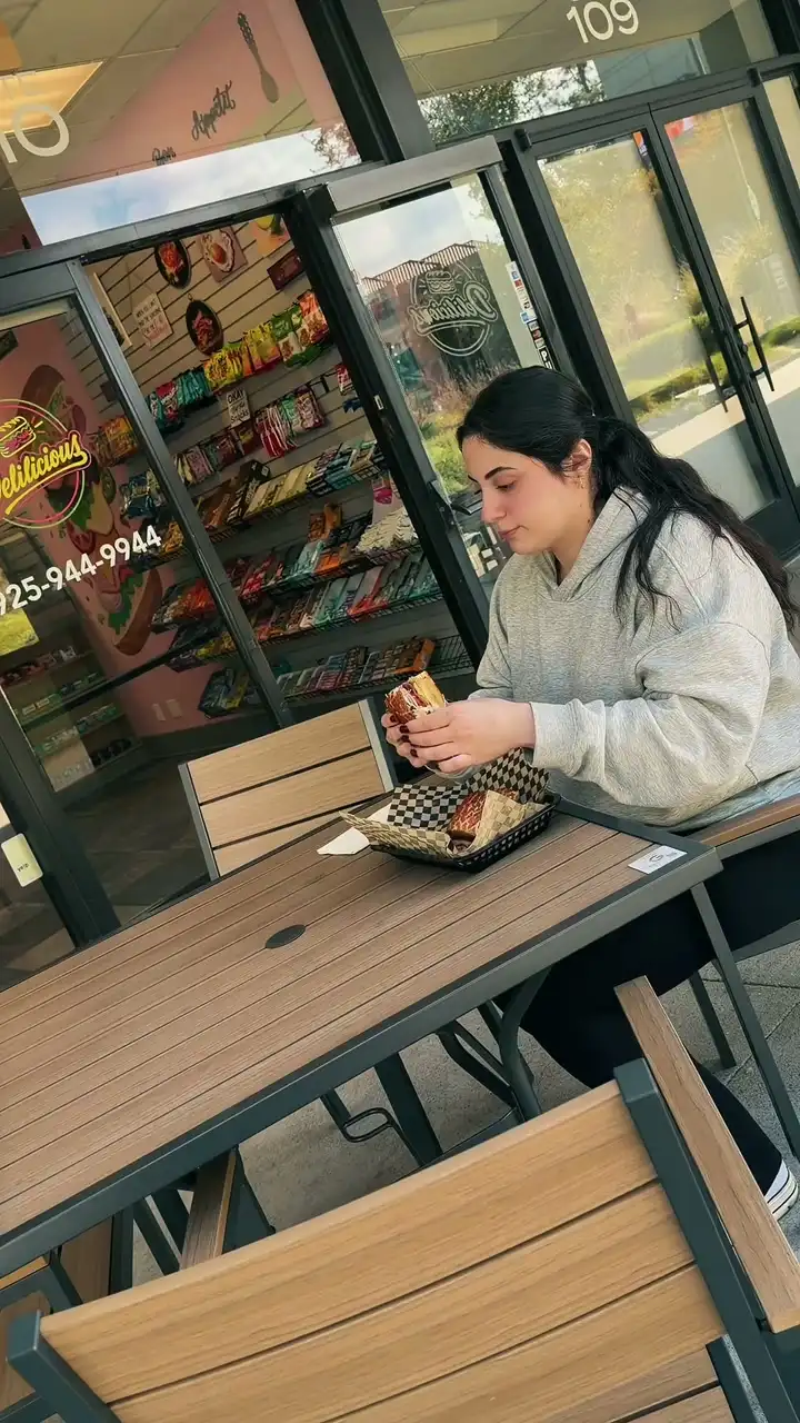A customer eating a sandwich outside Delilicious in Walnut Creek